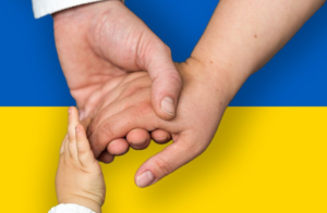 Hands held in front of a Ukrainian flag