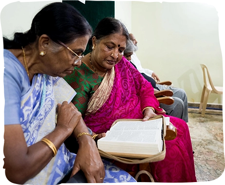 Two Indian women read the Bible together